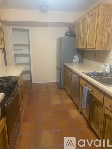 A kitchen with wooden cabinets and a tile floor.