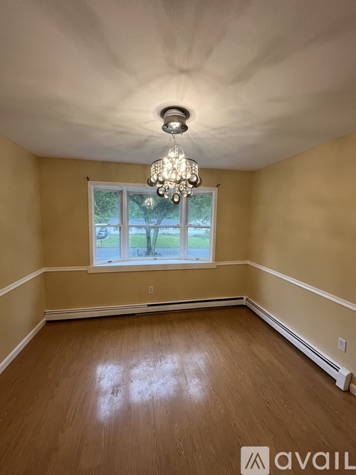 A room with wooden floors and a chandelier.