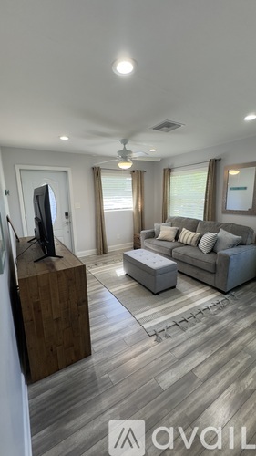 A modern living room with a grey sofa and a wooden cabinet.