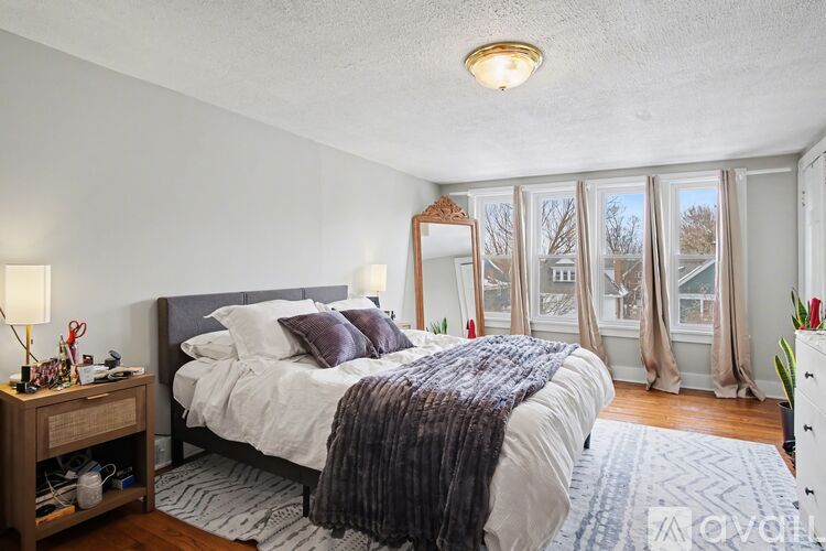 A bedroom with a large bed and a mirror on the wall.