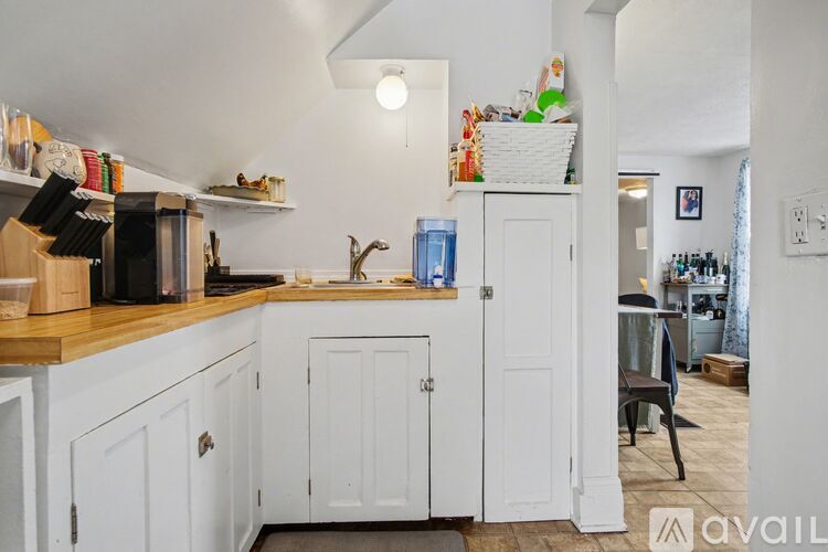 A kitchen with white cabinets and a wooden countertop.