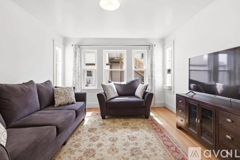 A living room with a grey couch and a black armchair.