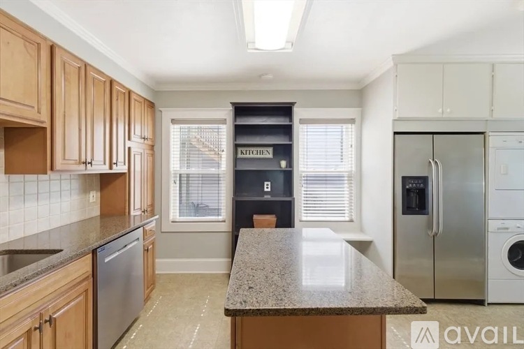 A kitchen with wooden cabinets and a granite countertop.