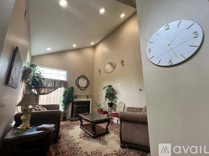 A living room with a large clock on the wall.
