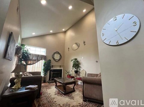 A living room with a large clock on the wall.