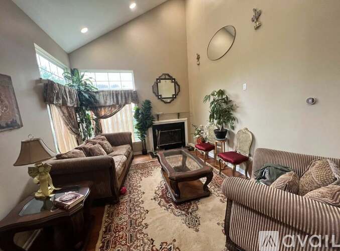 A living room with a couch, a chair, a coffee table, and a fireplace.