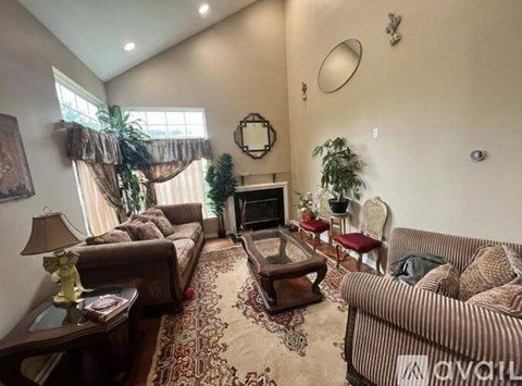 A living room with a couch, a chair, a coffee table, and a fireplace.