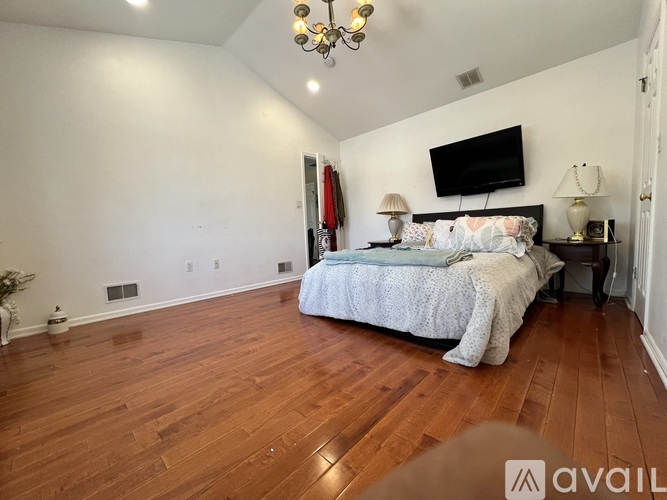 A bedroom with a large bed and a chandelier.