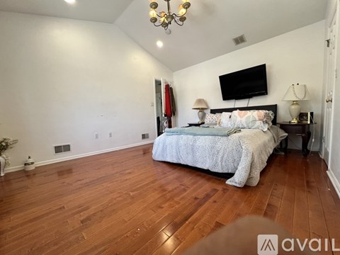 A bedroom with a large bed and a chandelier.