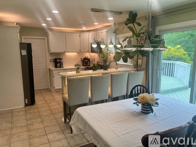 A kitchen with a table set for two and a refrigerator to the left.