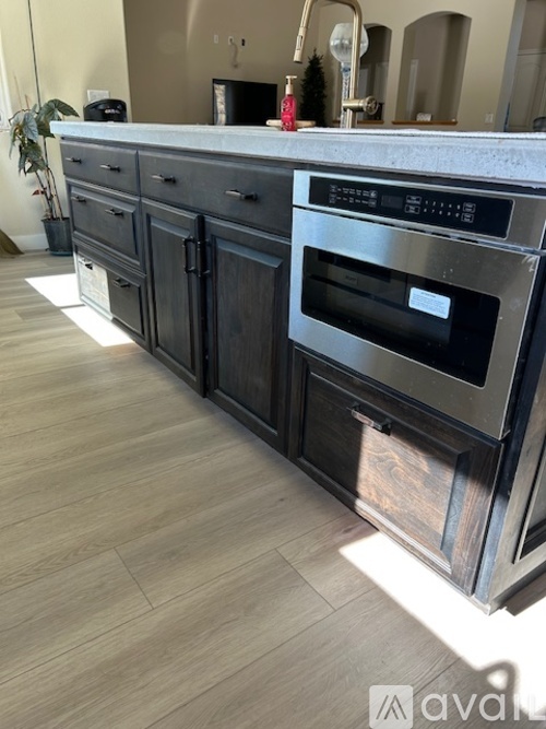 A modern kitchen with a stainless steel oven and dark wood cabinets.