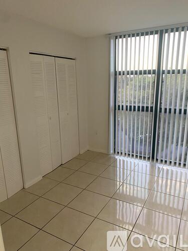 A room with white tiled floors and white closet doors.