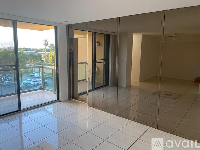 A spacious room with a glass door leading to a balcony.