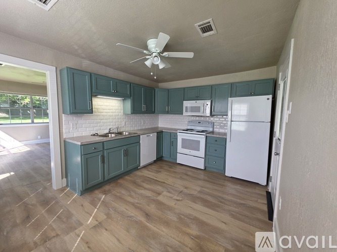 A kitchen with a white fridge, white oven, and white microwave.