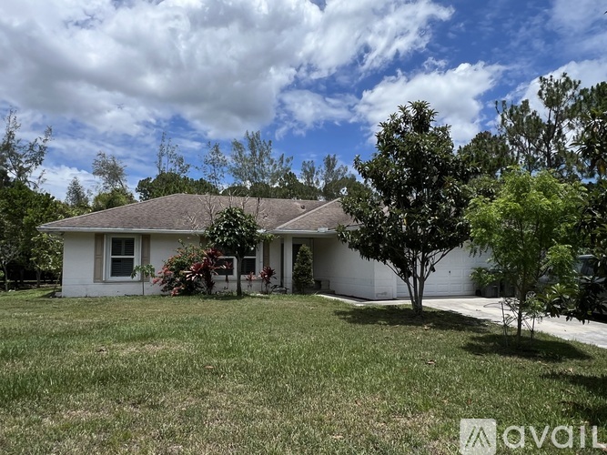 A house with a lawn and trees in front of it.