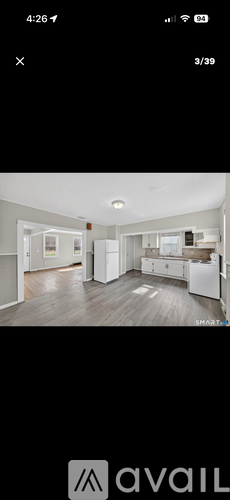 A room with a white fridge and a white cabinet.