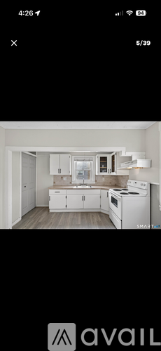 A modern kitchen with white cabinets and appliances.