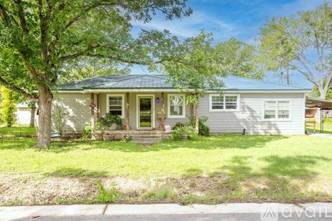 A house with a green tree in front of it.