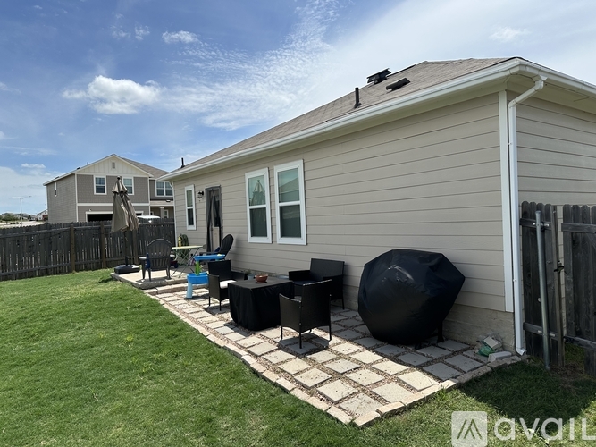 A backyard with a patio and a grill.