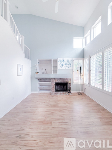 A spacious living room with a fireplace and built-in shelves.