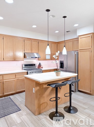 A kitchen with wooden cabinets and a pink backsplash.