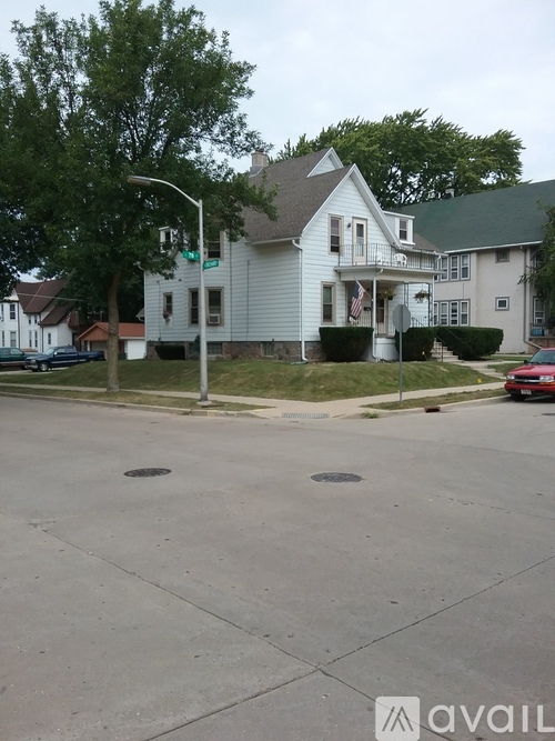 A street corner with a house and a green street sign.
