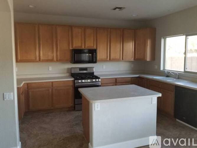 A kitchen with wooden cabinets and a black microwave.