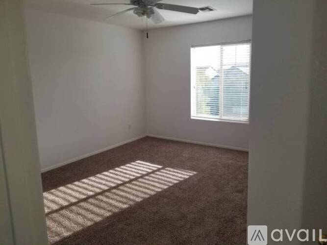A room with a carpet and a ceiling fan.