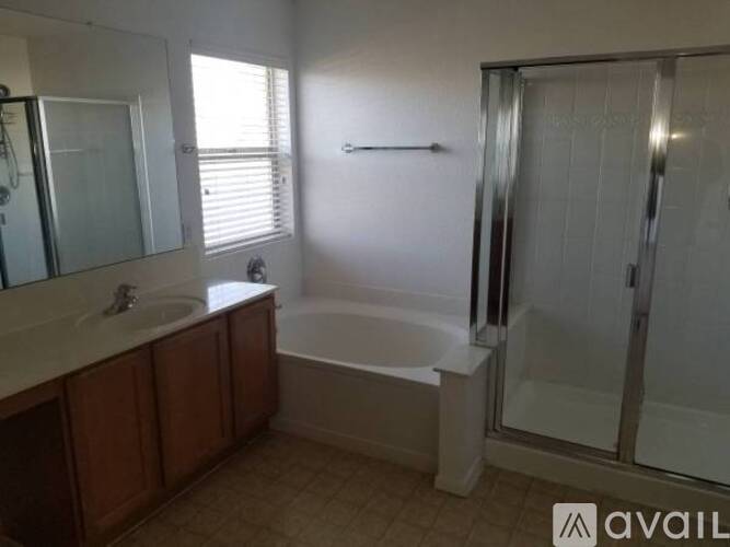 A bathroom with a tub, sink, and mirror.