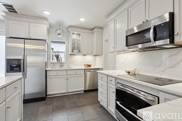 A kitchen with white cabinets and stainless steel appliances.