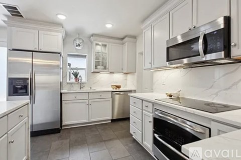 A kitchen with white cabinets and stainless steel appliances.