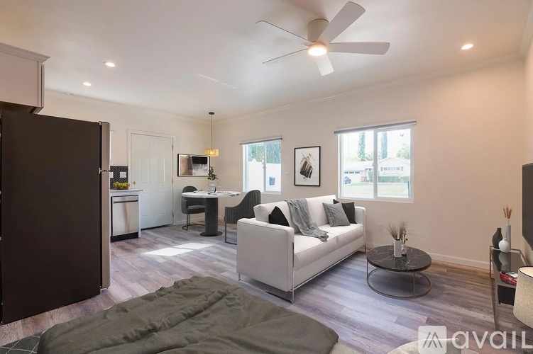 A living room with a white couch and a ceiling fan.