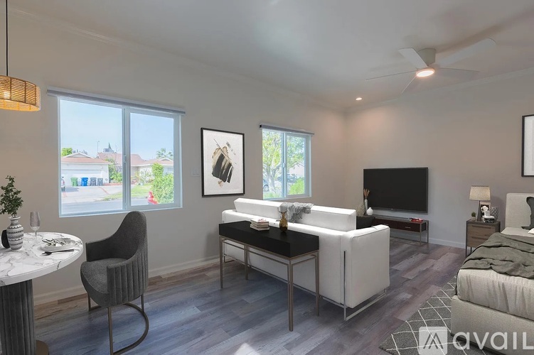 A living room with a grey chair, a white sofa, and a television.