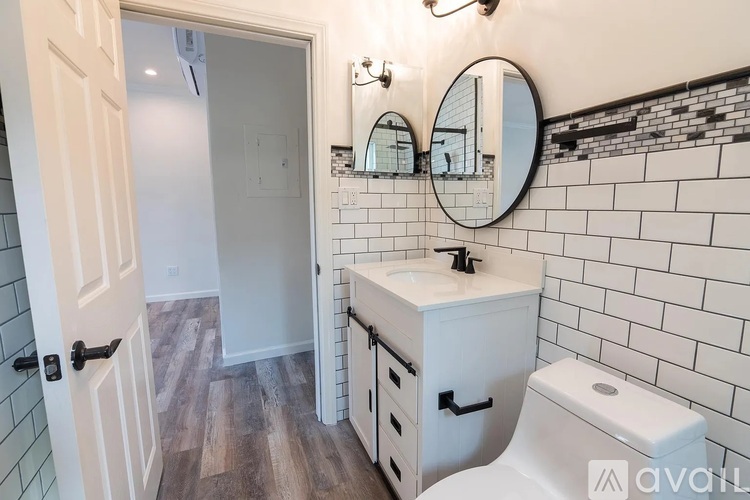 A bathroom with a white toilet, sink, and mirror.