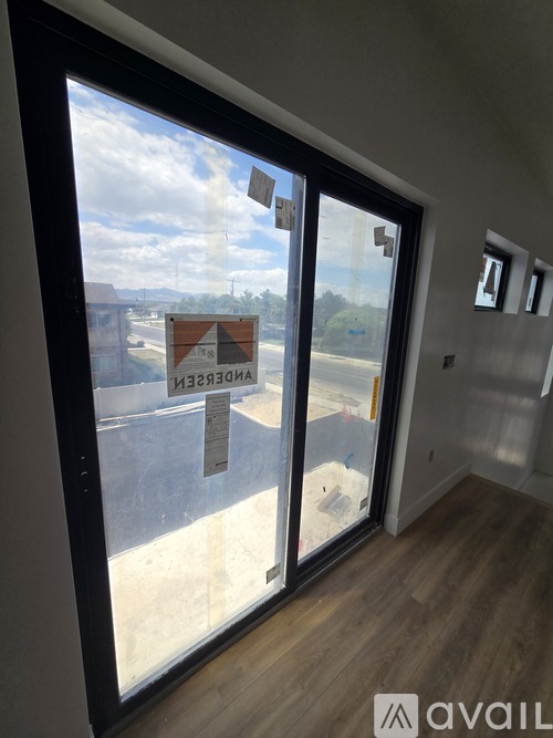 A room with a view of a construction site through a glass door.
