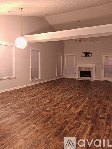 A room with wooden flooring and a fireplace.