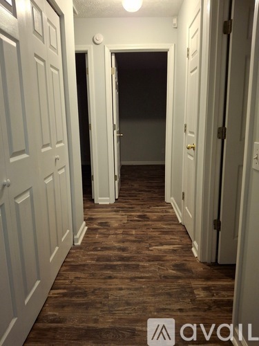 A hallway with white doors and wooden floors.