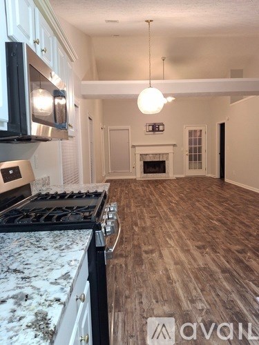 A kitchen with a granite counter top and wooden flooring.
