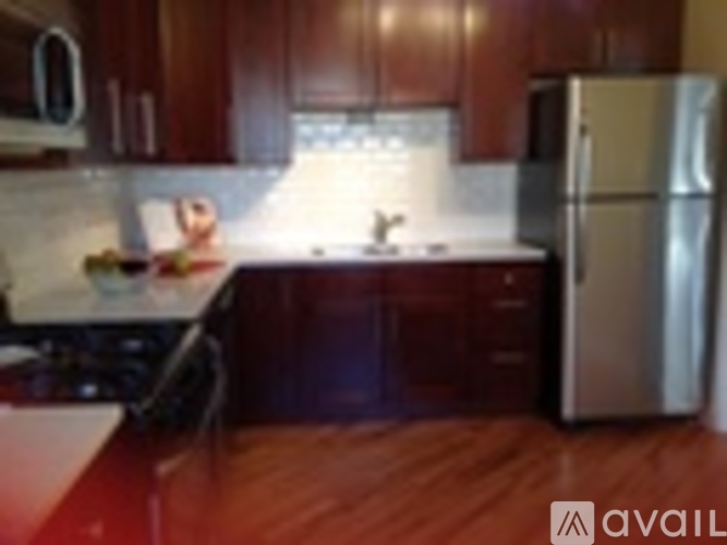 A kitchen with wooden cabinets and a stainless steel refrigerator.