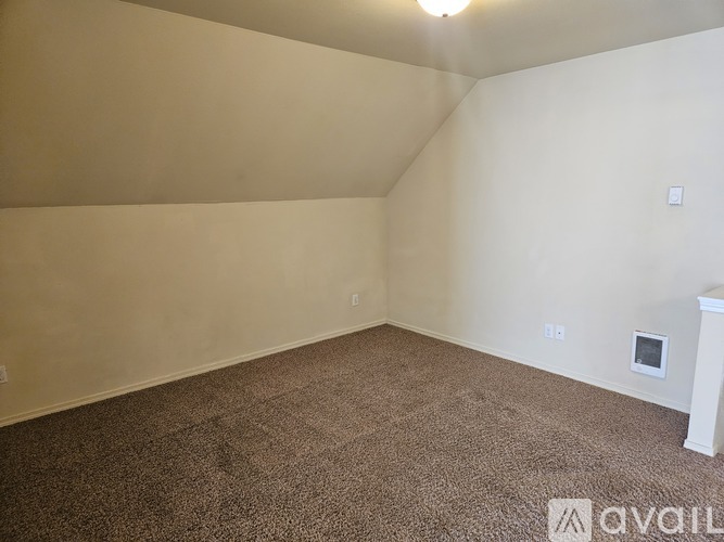 A room with carpeted floor and a white wall.