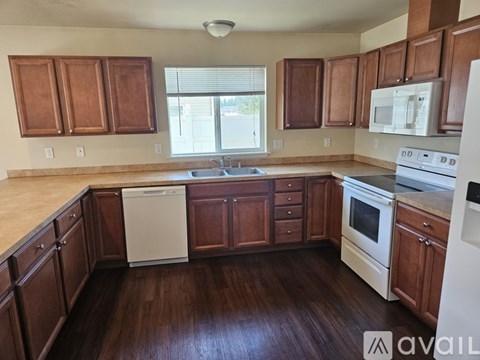 A kitchen with wooden cabinets and white appliances.