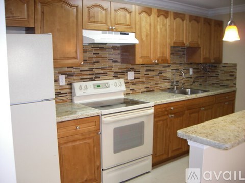 A kitchen with wooden cabinets and a white refrigerator.