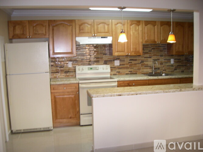 A kitchen with wooden cabinets and a white refrigerator.
