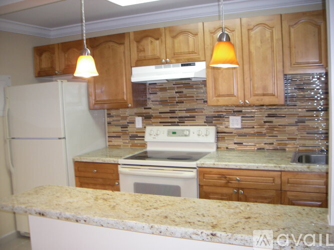 A kitchen with a white refrigerator and wooden cabinets.