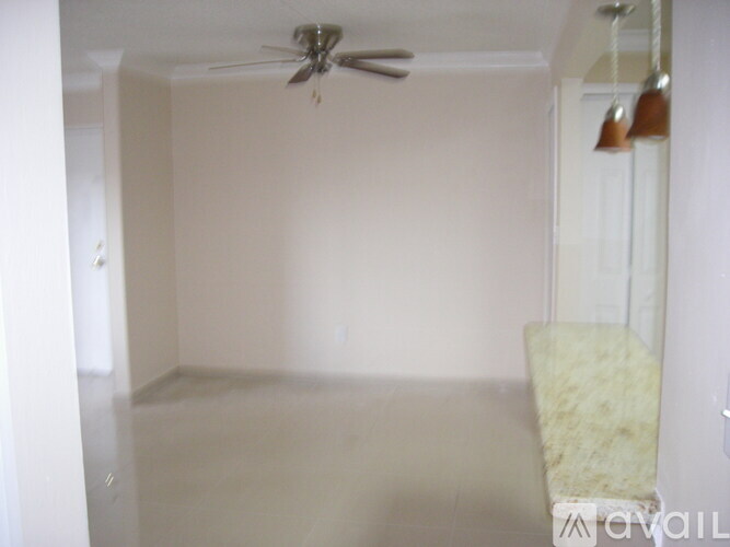 A room with a ceiling fan and a chair.