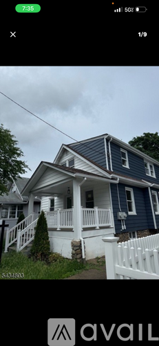 A blue house with white trim and a white picket fence.