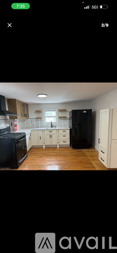 A kitchen with wooden floors and white cabinets.