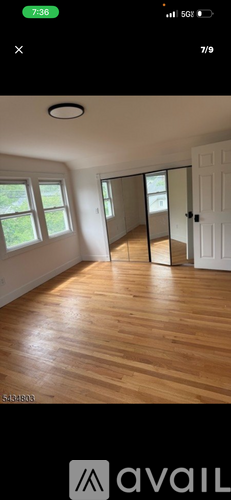 A room with wooden flooring and a sliding glass door.
