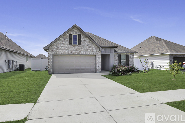 A house with a garage and a driveway in front of it.