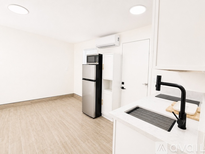 A kitchen with a sink, fridge, and microwave.
